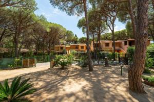 a park with a fence and trees and houses at Villetta Pineta in Santa Margherita di Pula