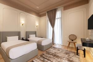 a hotel room with two beds and a television at Malak Palace Cairo Hotel in Cairo