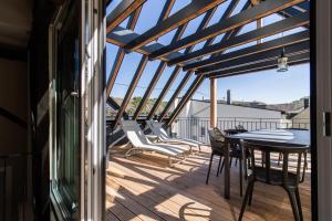 eine Terrasse mit Tisch und Stühlen auf einem Deck in der Unterkunft Emmis Appartements in Bremm