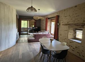 a living room with a table and a couch at Saisonnée - Gîtes de Charme en Aveyron in Centrès