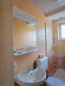 a bathroom with a sink and a toilet and a mirror at Villa Apollo Ohrid Lakeside in Ohrid