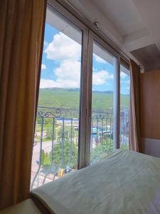 a bedroom with a large window looking out at a view at Villa Apollo Ohrid Lakeside in Ohrid +26 photos