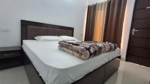 a bedroom with a bed with a blanket on it at Hotel Riversight in Uttarkāshi +5 photos