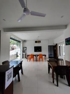 a living room with tables and chairs and a large window at Hotel Riversight in Uttarkāshi