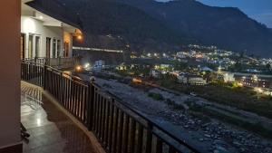 a balcony with a view of a city at night at Hotel Riversight in Uttarkāshi