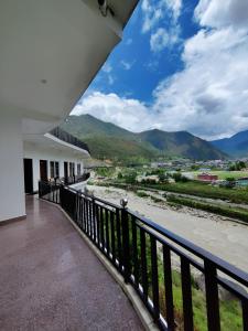 a balcony with a view of a river and mountains at Hotel Riversight in Uttarkāshi