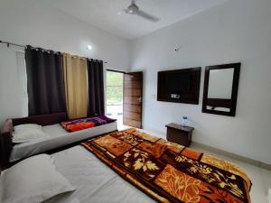 a bedroom with a bed and a television in it at Hotel Riversight in Uttarkāshi