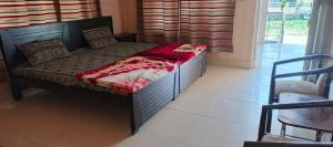 a small bed in a room with a bedskirtspectspectspectspects at Stone Man's Hotel Samana Heights in Battakundi