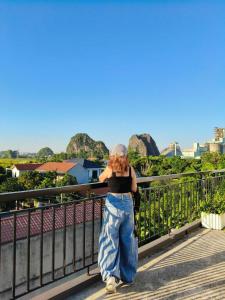a woman standing on a bridge talking on her cell phone at Tam coc Sylvani Homestay in Vũ Lâm