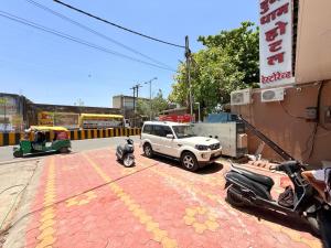 a white truck parked on a street with motorcycles at Shri Gopal Durga Dham Hotel And Restaurant in Ujjain +4 photos