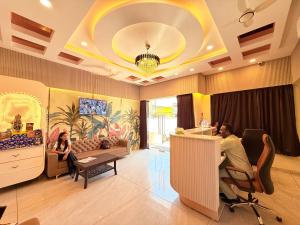 two people sitting at a table in a living room at Shri Gopal Durga Dham Hotel And Restaurant in Ujjain
