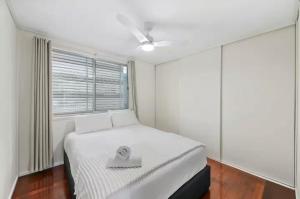 a bedroom with a bed and a window at Beach Side on Burke - Pet Friendly in Golden Beach