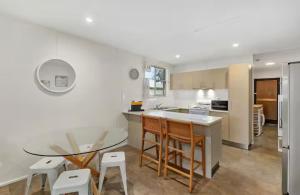 a kitchen with a table and a table and chairs at Beach Side on Burke - Pet Friendly in Golden Beach