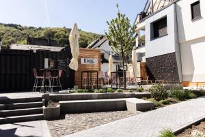 eine Terrasse mit Tisch und Stühlen neben einem Gebäude in der Unterkunft Emmis Appartements in Bremm