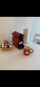 a coffee maker and a bowl of muffins and a cup of coffee at Apartment MICKEY in Interlaken