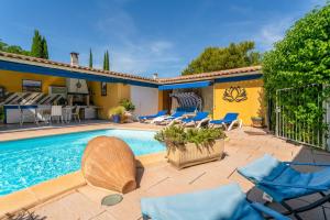a villa with a swimming pool and patio furniture at Le Soleillant Havre De Paix in L'Isle-sur-la-Sorgue