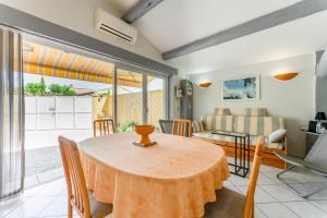 a dining room with a table and a couch at Le Soleillant Havre De Paix in L'Isle-sur-la-Sorgue