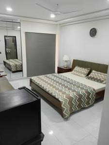 a bedroom with a large bed and a mirror at Margalla Hills View Apartment Islamabad in Islamabad