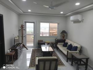 a living room with a couch and a table at Margalla Hills View Apartment Islamabad in Islamabad