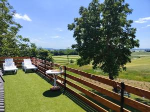a fence with two chairs and a table on the grass at Casa33 in Dobrovnik +7 photos