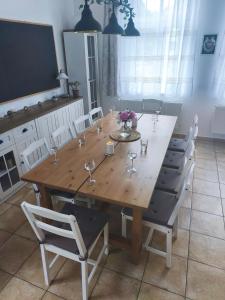 a wooden table and chairs with wine glasses on it at Vila Rychleby Javorník in Javorník