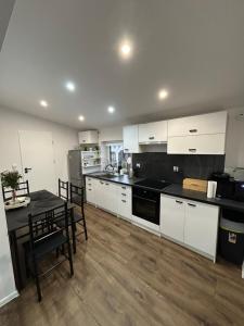 a kitchen with white cabinets and a table and chairs at Noclegi Leśne Bagno in Zwierzyniec