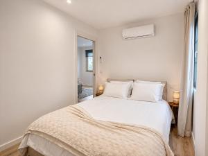 a white bedroom with a bed with white sheets and pillows at Casa da Villa in Monção