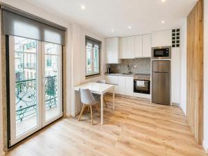 a kitchen with a white table and a large window at Casa da Villa in Monção