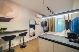 a hotel room with a bed and two bar stools at Loco Studio Apartments - Private Entrance & Self Check-in in Zagreb