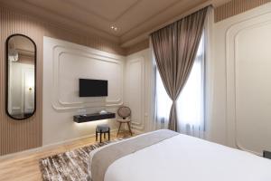 a bedroom with a bed and a mirror and a tv at Malak Palace Cairo Hotel in Cairo