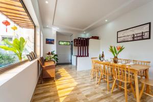 a dining room with a wooden table and chairs at Laughter Garden villas in Tân Thành (1)