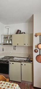 a kitchen with white cabinets and a stove top oven at Vecchio Mulino-Ceci's Flat in Entracque