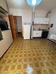 a kitchen with a white refrigerator and a tile floor at Vecchio Mulino-Ceci's Flat in Entracque