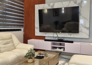 a living room with a large tv and a couch at Appartement Une Chambre Salon Ouando - SKYFORCE in Porto-Novo