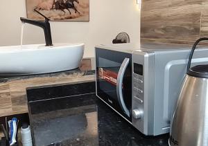 a microwave sitting on a counter next to a sink at Appartement Une Chambre Salon Ouando - SKYFORCE in Porto-Novo +7 photos