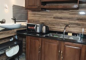 a kitchen with a sink and a microwave at Appartement Une Chambre Salon Ouando - SKYFORCE in Porto-Novo