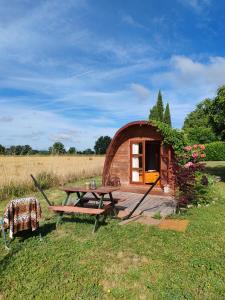 a wooden cabin with a picnic table in the grass at Les Gîtes de Botte in Duras