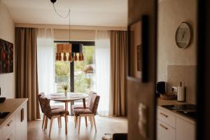 a kitchen with a table and chairs and a window at Kozia Chata - apartamenty nad rzeką in Brenna