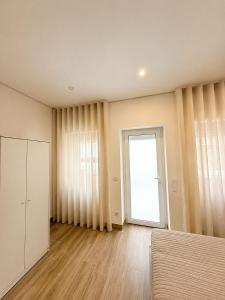 an empty room with a bed and a window at Casa Rabiosa in Nazaré