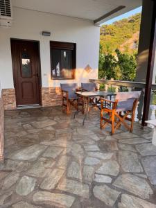 a patio with a table and chairs on a stone floor at Pelagos Beachfront in Panormos Skopelos