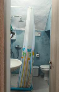 a bathroom with a shower curtain and a sink at The Mill House George in Symi +30 photos