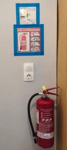 a fire extinguisher is hanging on a wall with a fire extinguisherventory at The Mill House George in Symi