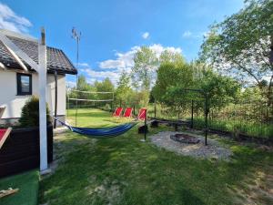 a backyard with a hammock and a fire pit at Noclegi Leśne Bagno in Zwierzyniec