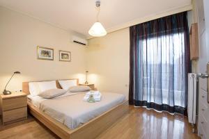 - une chambre avec un lit et une grande fenêtre dans l'établissement Dimitris Home, à Athènes