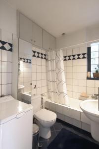 La salle de bains est pourvue de toilettes, d'une baignoire et d'un lavabo. dans l'établissement Dimitris Home, à Athènes