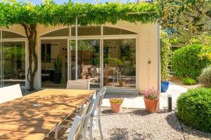 a dining table and chairs in front of a house at Chambre D'hôtes - Les Hirondelles in Mirabel-aux-Baronnies
