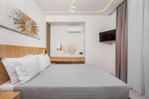 a hotel room with a bed and a tv at Adessa Villas in Afitos