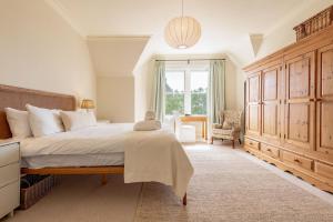 a bedroom with a large bed and a window at Hazelton Townhouse - Crail in Crail