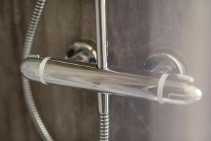 a close up of a shower head with a hose at Hazelton Townhouse - Crail in Crail +36 photos