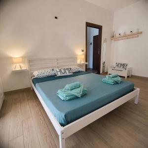 a bedroom with a large bed with two towels on it at Riflessi nosTrani - Seaside Rooms in Trani +82 photos